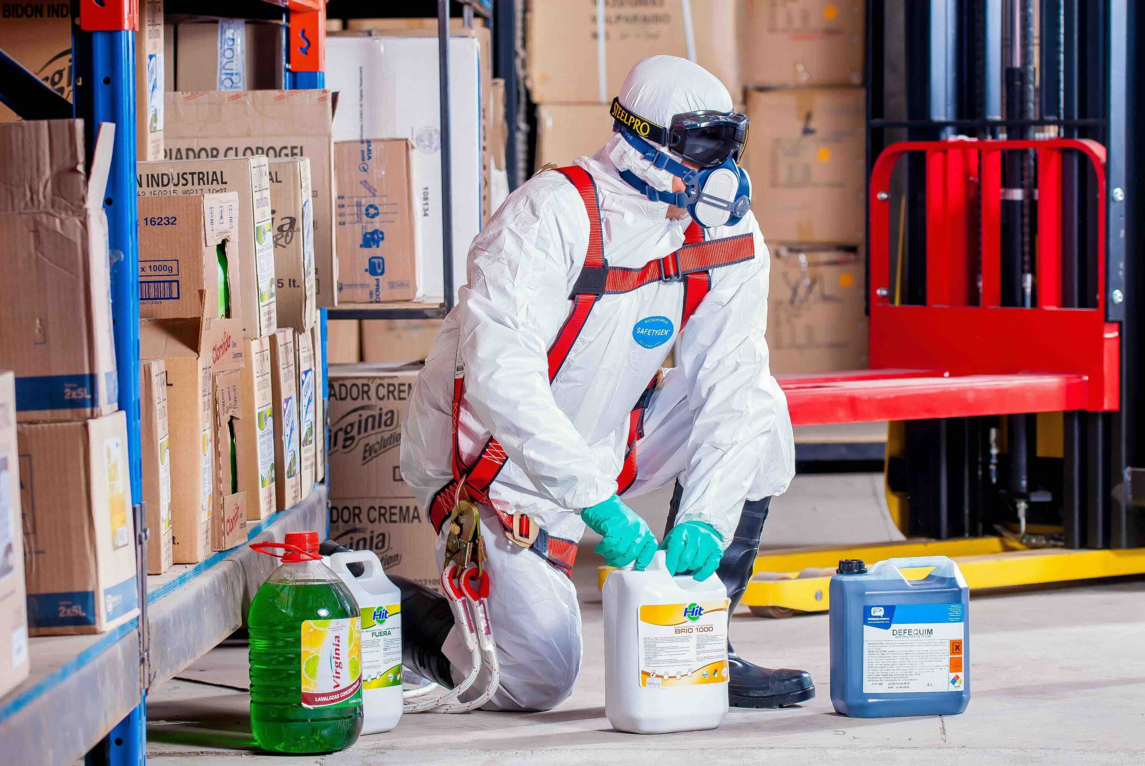 Person handling chemicals in a factory using PPE